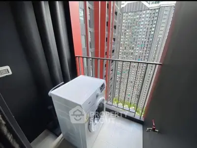Compact balcony with washing machine and urban high-rise view