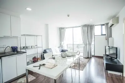 Bright modern living room with open kitchen and balcony view