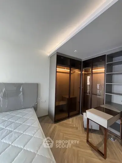 Modern bedroom with sleek wardrobe and stylish desk in a contemporary apartment.