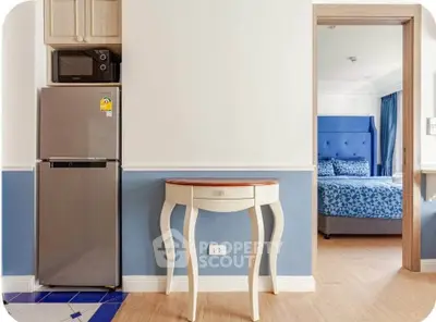 Charming interior with modern kitchen appliances and cozy bedroom view, perfect for stylish living.