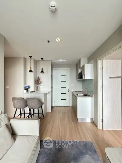 Modern open-plan living room and kitchen with sleek design and neutral tones