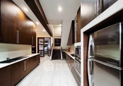Spacious modern kitchen with sleek cabinetry and stainless steel appliances.