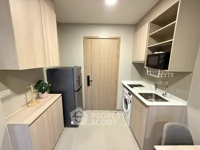 Modern compact kitchen with integrated appliances and sleek cabinetry