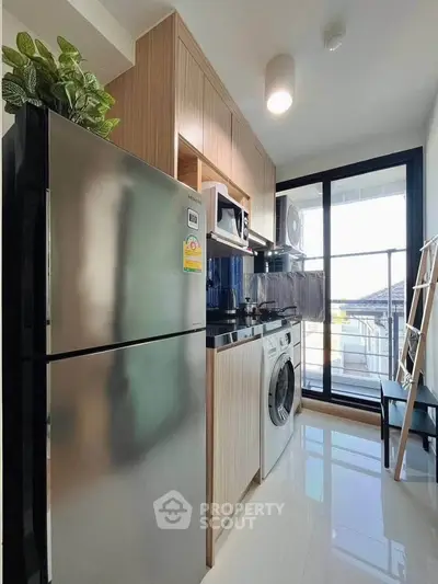 Modern kitchen with sleek appliances and balcony view in stylish apartment