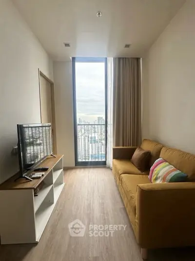 Cozy living room with city view, modern sofa, and sleek TV setup.