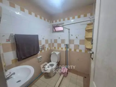 Cozy bathroom with tiled walls and essential fixtures, perfect for a compact living space.