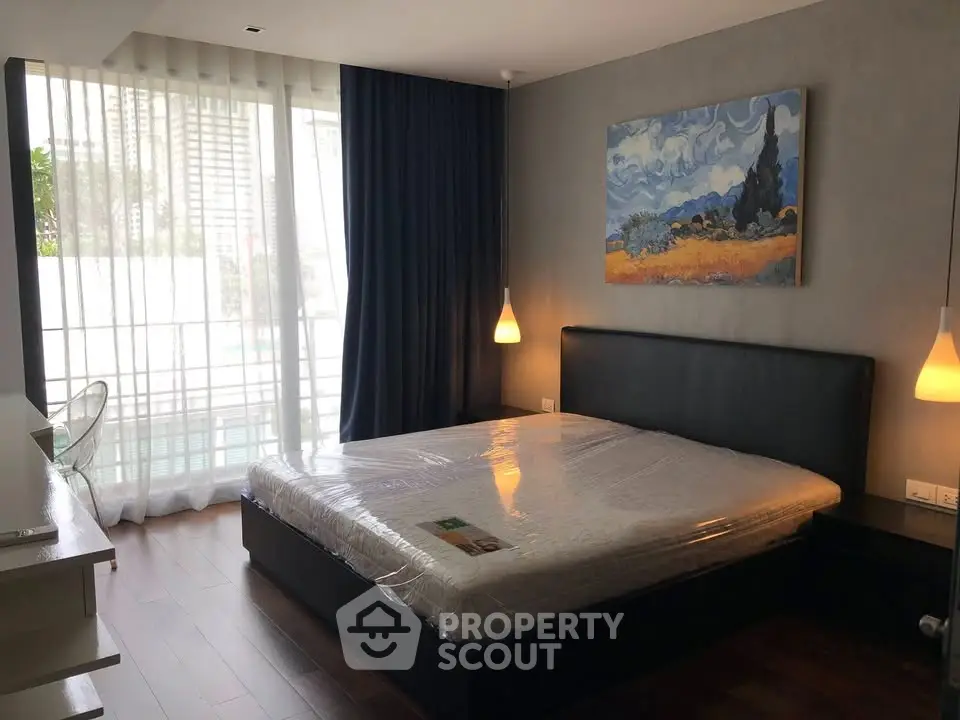 Modern bedroom with large window, stylish decor, and cozy lighting in a luxury apartment.