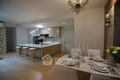Luxurious open-layout kitchen and dining area with elegant chandelier and modern decor.