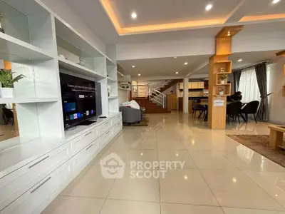 Spacious open-plan living room with modern decor and ample natural light