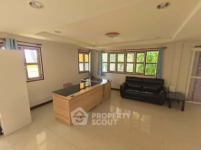 Spacious living room with modern furniture and large windows offering natural light.