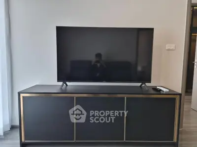 Modern living room with sleek TV stand and large flat-screen TV, perfect for entertainment.