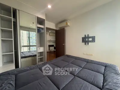 Modern bedroom with built-in wardrobe and air conditioning in a high-rise apartment.
