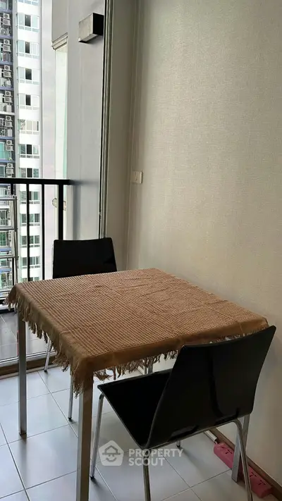 Cozy dining area with a table for two, featuring a city view from the balcony.
