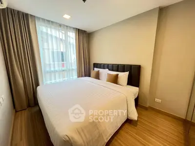 Cozy and modern bedroom with large window and stylish decor in a contemporary apartment.