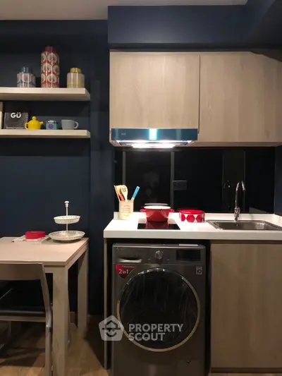 Modern compact kitchen with sleek cabinetry and integrated washing machine