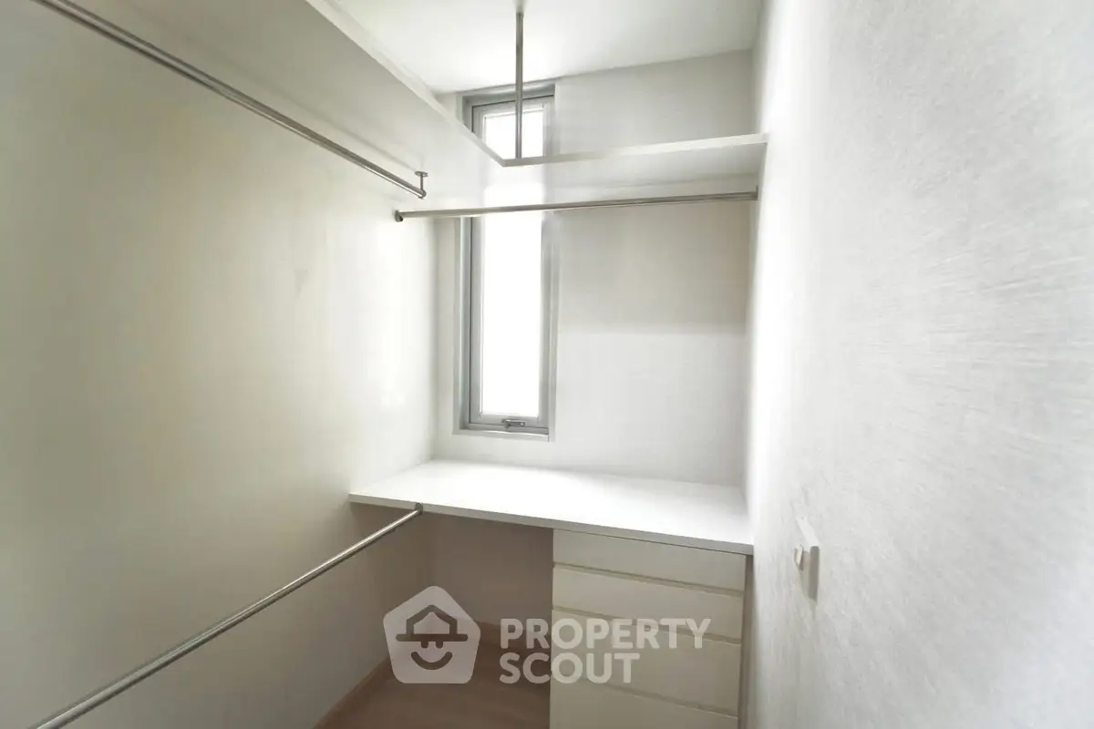 Spacious walk-in closet with natural light and ample storage space.
