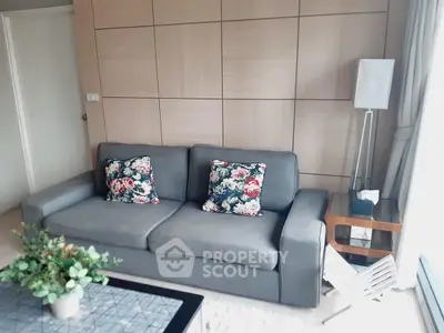 Stylish living room with modern gray sofa and floral cushions, perfect for cozy relaxation.
