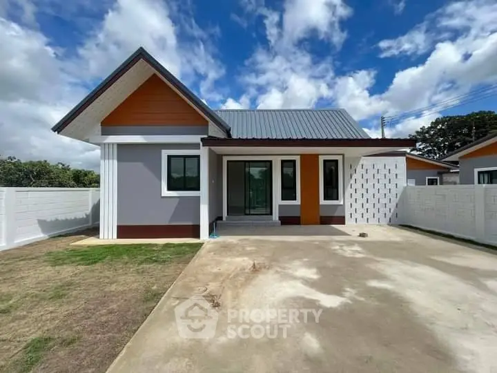 Charming modern house with spacious driveway and stylish facade under a bright blue sky.