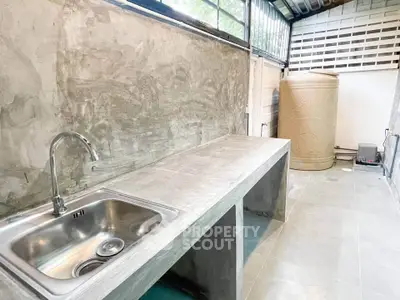 Modern industrial-style kitchen with concrete countertops and stainless steel sink