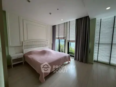 Spacious bedroom with large windows and elegant decor in modern apartment