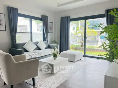 Modern living room with large windows, stylish furniture, and garden view, perfect for relaxation and entertaining.