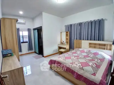 Spacious bedroom with modern decor and ample natural light, featuring a cozy bed and stylish furniture.