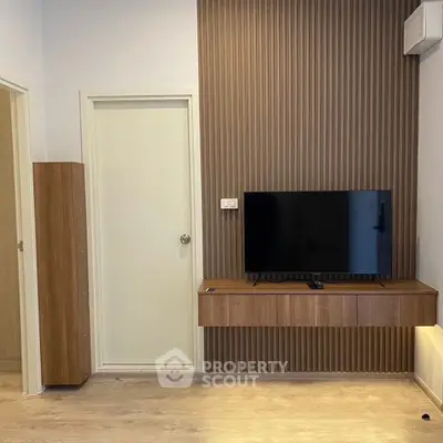 Modern living room with sleek TV unit and wood paneling