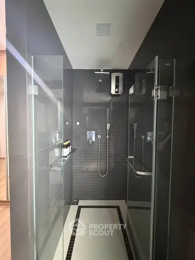 Modern bathroom with sleek glass shower doors and contemporary fixtures.