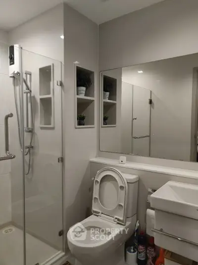 Modern bathroom with glass shower and sleek fixtures in contemporary home.