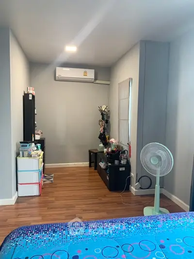 Cozy bedroom with wooden flooring and air conditioning unit