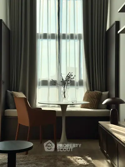 Chic modern living room with tall windows, elegant seating, and stylish decor for a cozy ambiance.