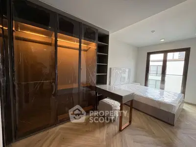 Modern bedroom with large wardrobe and balcony access, featuring sleek design and natural light.