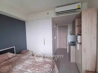 Modern bedroom with built-in wardrobe and compact kitchenette, ideal for urban living.