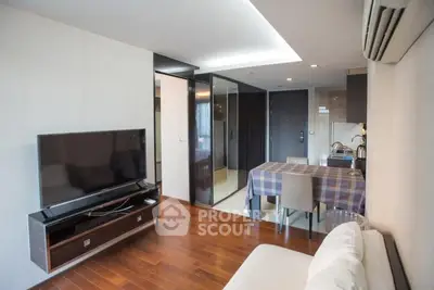 Modern living room with sleek TV setup and dining area, featuring wooden flooring and contemporary design.