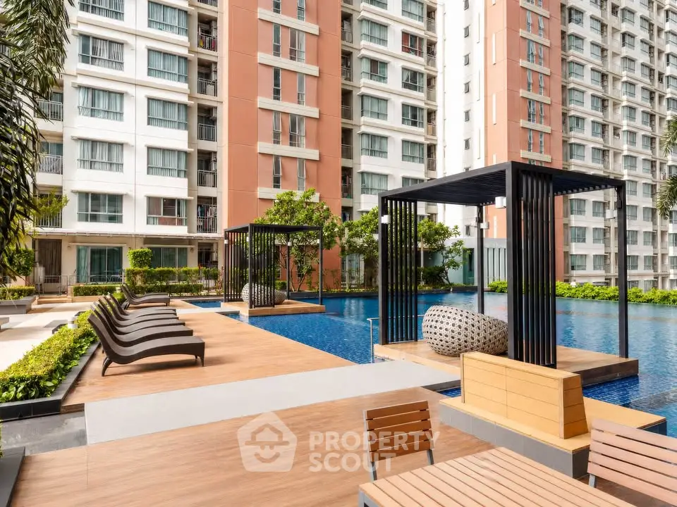 Luxurious apartment complex with modern poolside amenities and stylish outdoor seating.