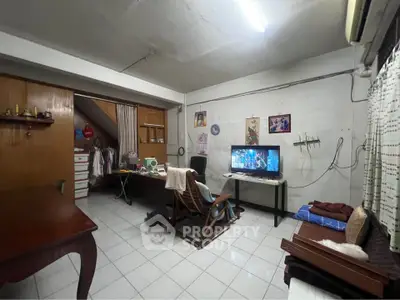 Cozy living room with TV, desk, and air conditioning in a compact space.