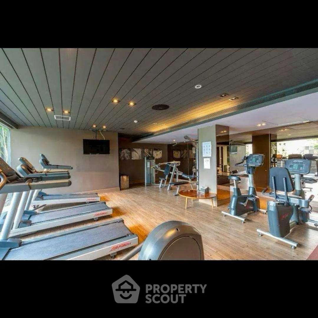 Spacious modern gym with state-of-the-art equipment and stylish design.