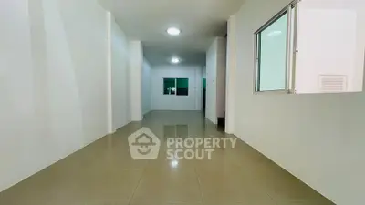 Spacious open-plan interior with tiled flooring and bright lighting, ideal for versatile living arrangements.
