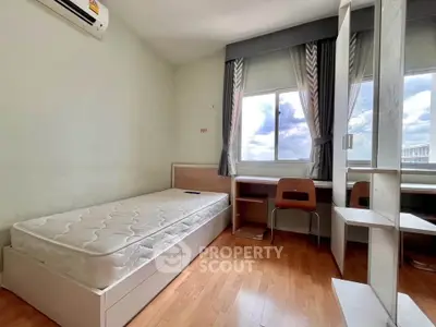 Cozy bedroom with wooden flooring, single bed, desk, and large window with curtains.
