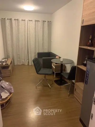 Cozy living room with modern furniture and wooden flooring in a compact apartment.