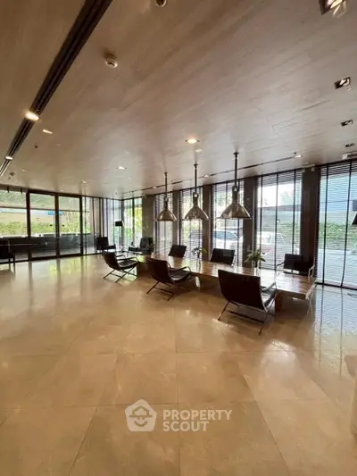 Spacious modern living room with floor-to-ceiling windows and elegant lighting.