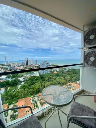 Stunning high-rise balcony with panoramic city and ocean views, perfect for relaxation.