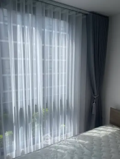 Bright bedroom with sheer curtains and natural light