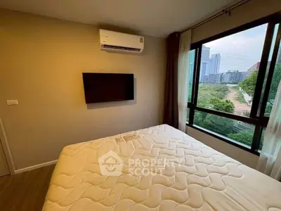 Cozy bedroom with large window and air conditioning, offering a serene view of the cityscape.