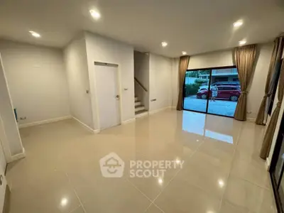 Spacious modern living room with large windows and sleek tile flooring