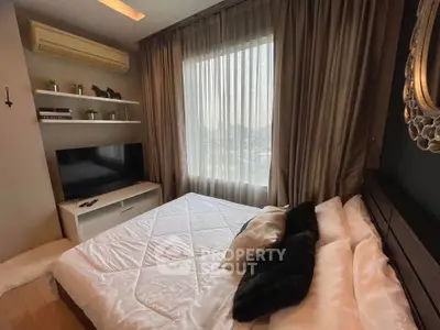 Cozy bedroom with modern decor, featuring a large window, TV, and stylish bedding for ultimate comfort.
