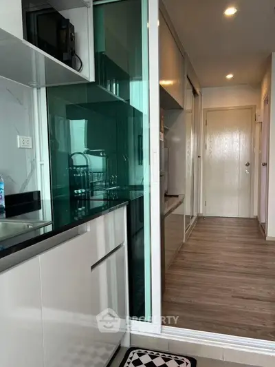 Modern kitchen with sleek cabinetry and glass accents in a stylish apartment.