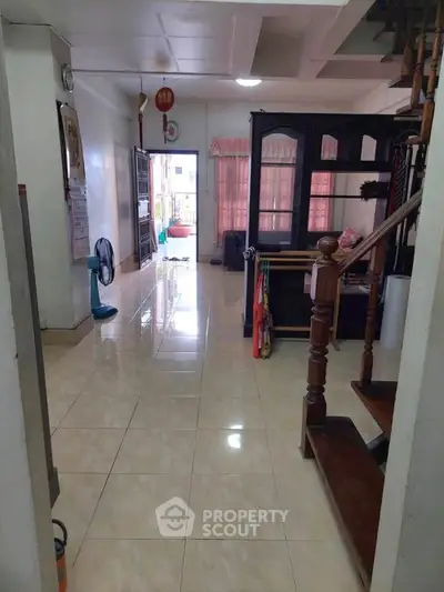 Spacious open-layout living area with tiled flooring and natural light