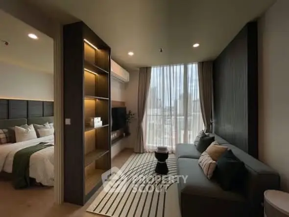 Modern living room with cozy sofa and stylish decor adjacent to a bedroom.