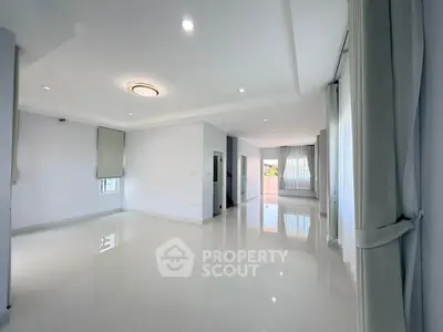 Spacious and bright living room with modern design and large windows in a luxury home.